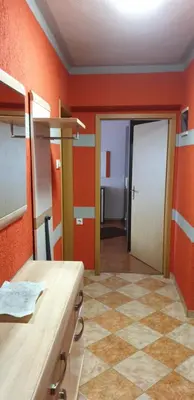 a kitchen with orange walls and a tile floor at Sana apartment in Sanski most