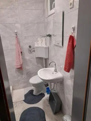 a bathroom with a white sink and a toilet at Irma in Tuzla
