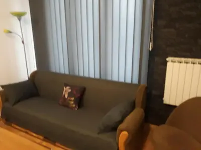 a living room with a green couch with a pillow at Irma in Tuzla