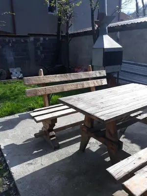 a wooden picnic table sitting next to a grill at City Apartment in Visoko