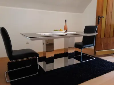 a dining room table with two chairs and a wine bottle at City Apartment in Visoko