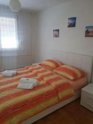 a bedroom with a large bed with two towels on it at Apartman Taša in Banja Luka