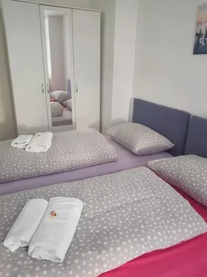 a bedroom with two twin beds and a mirror at Apartman Taša in Banja Luka