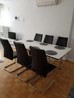 a conference room with a white table and black chairs at Apartman Taša in Banja Luka
