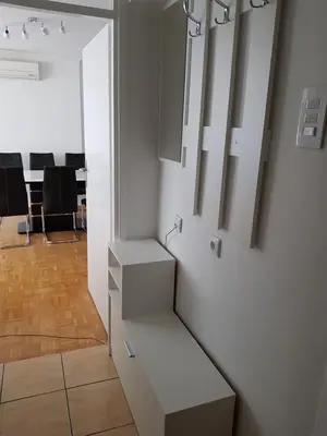 a living room with white cabinets and a table at Apartman Taša in Banja Luka