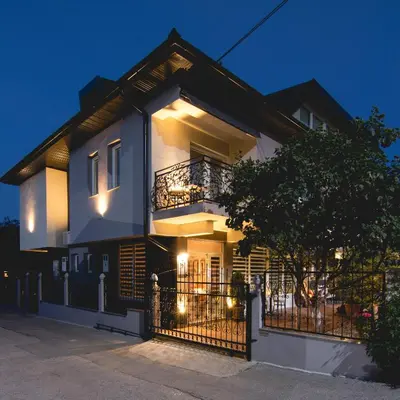 a white house with a balcony at night at APARTMENTS VRANAS in Visoko