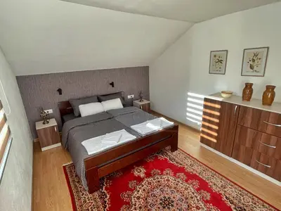 a bedroom with a bed and a red rug at Holiday Residence Burić in Visoko