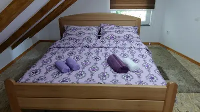 a bed with purple sheets and purple pillows at Villa Queen in Visoko