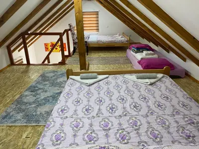 a attic room with two beds in a attic at Villa Queen in Visoko