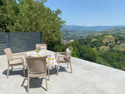 a table and chairs on a patio with a view at Villa Queen in Visoko