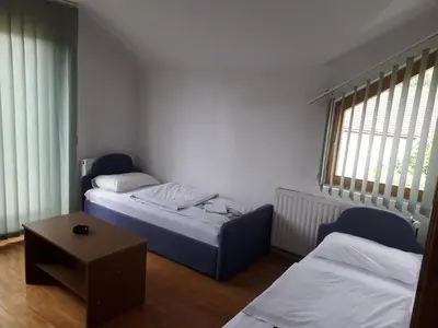 a small room with two beds and a table at Motel Tetrijeb Sipovo in Šipovo