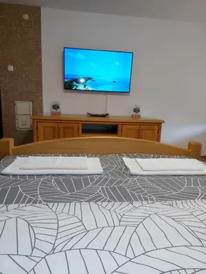 a bedroom with a bed with a flat screen tv on the wall at Panorama Travnik in Travnik