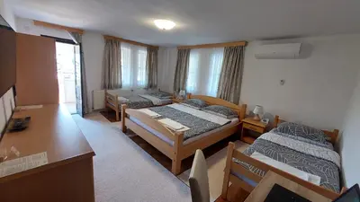a hotel room with two beds and a desk at Panorama Travnik in Travnik