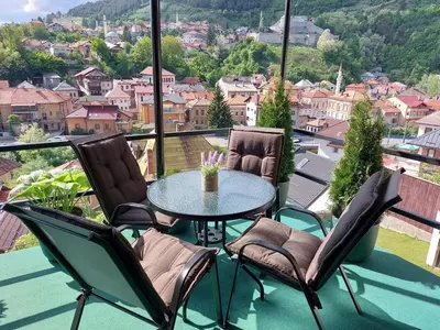a table and chairs on a balcony with a view at Panorama Travnik in Travnik