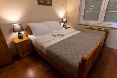 a bedroom with a large bed with two lamps at Motel Atos in Laktaši