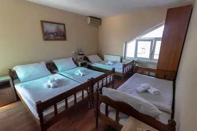a room with three beds and a window at Motel Atos in Laktaši