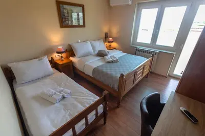a bedroom with two beds and two windows at Motel Atos in Laktaši