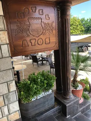 a sign on a pole with some plants at Motel Atos in Laktaši