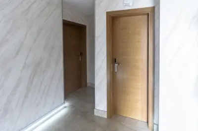 a hallway with a wooden door in a white wall at Motel Atos in Laktaši