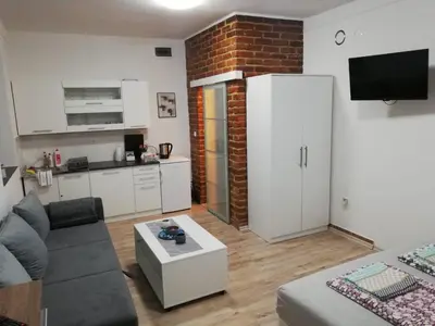 a small living room with a couch and a kitchen at Helly's apartman - self check-in - in Jajce
