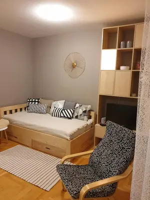 a small bedroom with a bed and a chair at Stan na dan 