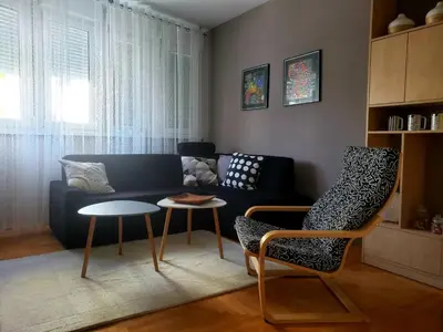 a living room with a couch and a table and chairs at Stan na dan 