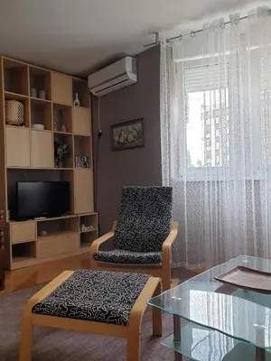 a living room with a chair and a tv and a table at Stan na dan 