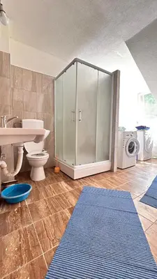 a bathroom with a toilet and a sink and a washing machine at Apartman Torlakovac in Donji Vakuf