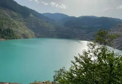 a view of a large blue lake in the mountains at Villa Sarajevo in Vareš