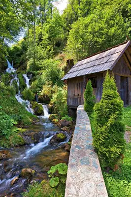 a bridge over a stream next to a cabin at Villa Sarajevo in Vareš