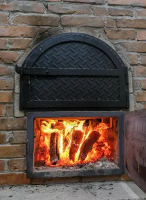 a brick oven with meat cooking in it at Villa Sarajevo in Vareš