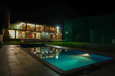 a swimming pool in front of a house at night at Villa Sarajevo in Vareš