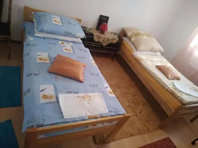 a bedroom with two twin beds with blue sheets at Apartman Ana in Livno