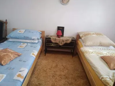 a bedroom with two beds and a table with a lamp at Apartman Ana in Livno
