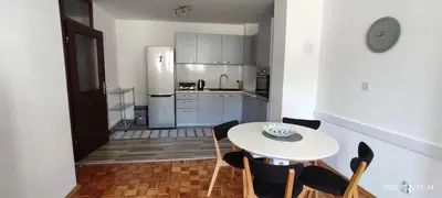 a kitchen with a table and chairs and a refrigerator at Apartment Emina in Travnik