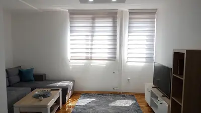 a living room with a couch and a window with shutters at Apartment Emina in Travnik