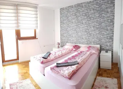 a bedroom with a pink bed and a brick wall at Apartment Emina in Travnik