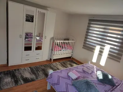 a bedroom with a purple bed and a crib at Kuća Vila Nina in Tomislavgrad