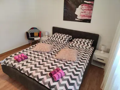 a bed with pink pillows on it in a bedroom at Kuća Vila Nina in Tomislavgrad