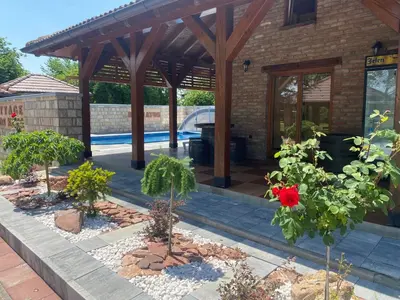 a garden with trees and a pavilion with a pool at Vikendica Atos in Nova Topola