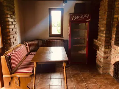a booth with a bench and a table in a restaurant at Vikendica Atos in Nova Topola