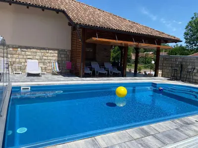 a swimming pool with a yellow ball in front of a house at Vikendica Atos in Nova Topola