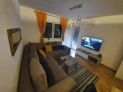 a living room with a couch and a flat screen tv at Apartman Lux Doboj in Doboj