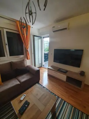 a living room with a couch and a flat screen tv at Apartman Lux Doboj in Doboj