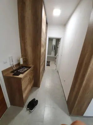 a hallway of a room with a dresser and shoes at Apartman Lux Doboj in Doboj