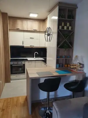 a kitchen with a counter and two bar stools at Apartman Lux Doboj in Doboj
