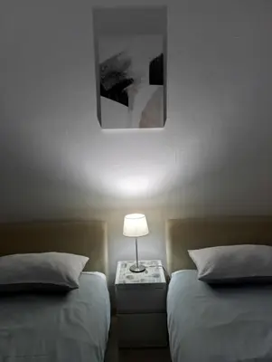 a bedroom with two beds and a lamp on a table at Studio apartman Ela in Travnik