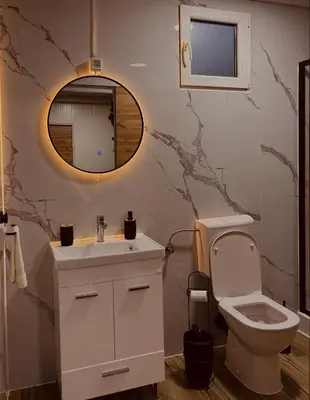 a bathroom with a sink and a toilet and a mirror at Apartman Deluxe Una Holiday in Bihać