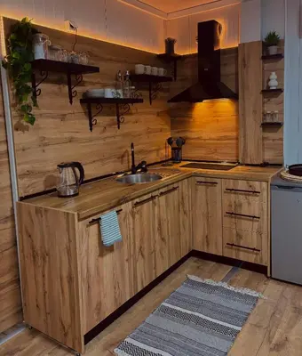 a kitchen with wooden cabinets and a sink at Apartman Deluxe Una Holiday in Bihać