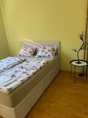 a bed with pink pillows and a table in a room at Villa Sun Visoko in Visoko